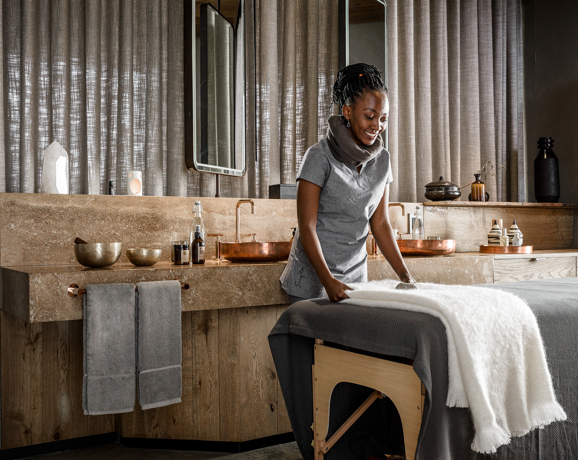 a masseuse preparing a massage bed