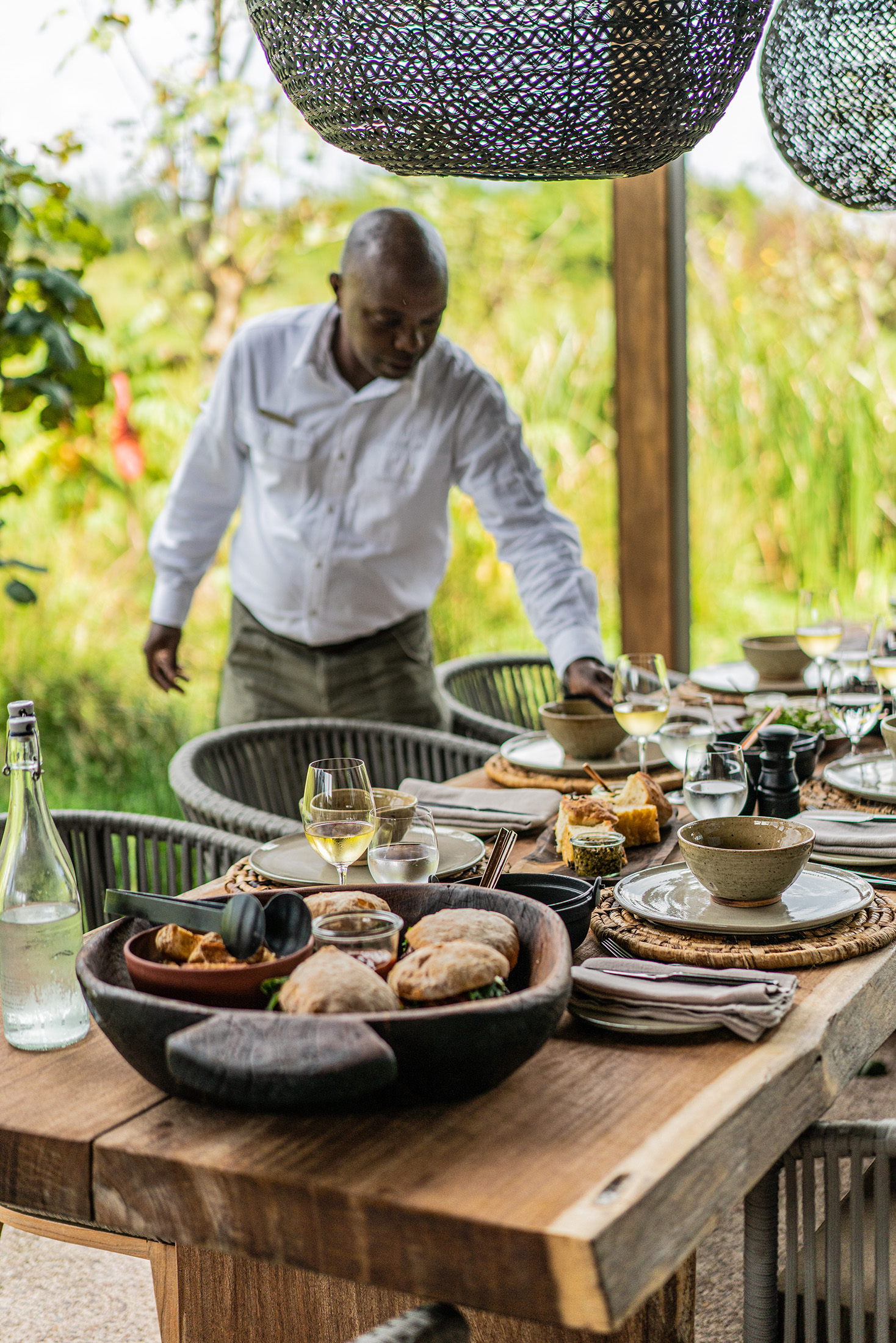A server preparing a dining table with food